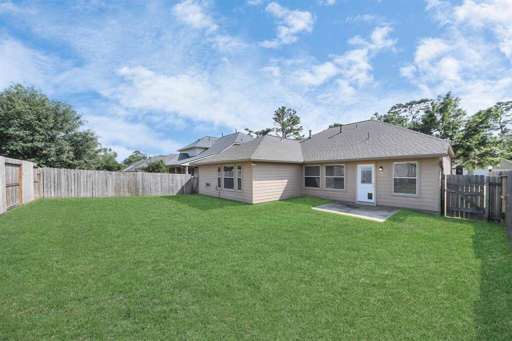 A wide view of the home’s exterior showcases ample yard space and the inviting back patio.