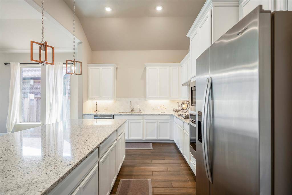 Plenty of storage in this light and bright granite island kitchen.