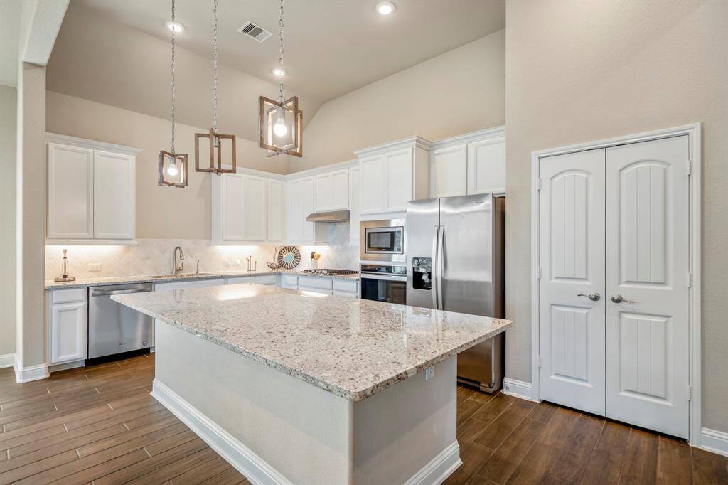Pendant lighting over the kitchen island that seats 4 people comfortably.