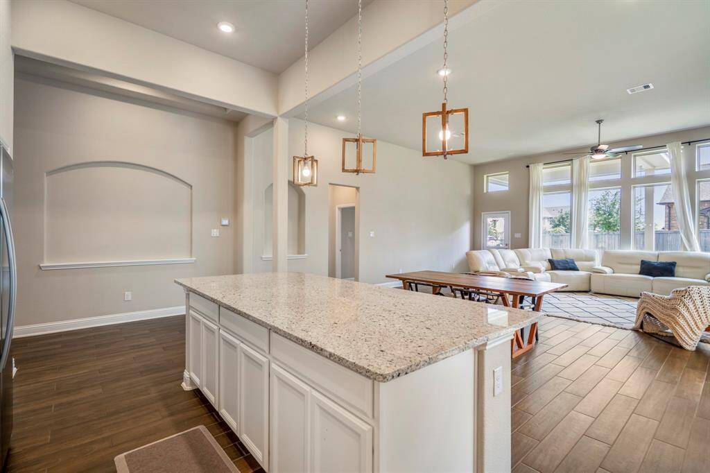 The flow from the kitchen to the dining to the living. Hallway in the middle of the picture leads to the primary bedroom and full bathroom.