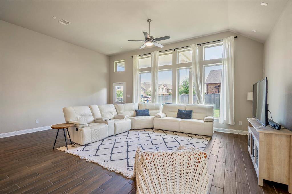 Living space with the current furniture. Large enough for Texas-sized sectionals and other full-sized furniture pieces. Floor-to ceiling windows overlook the quiet backyard space.