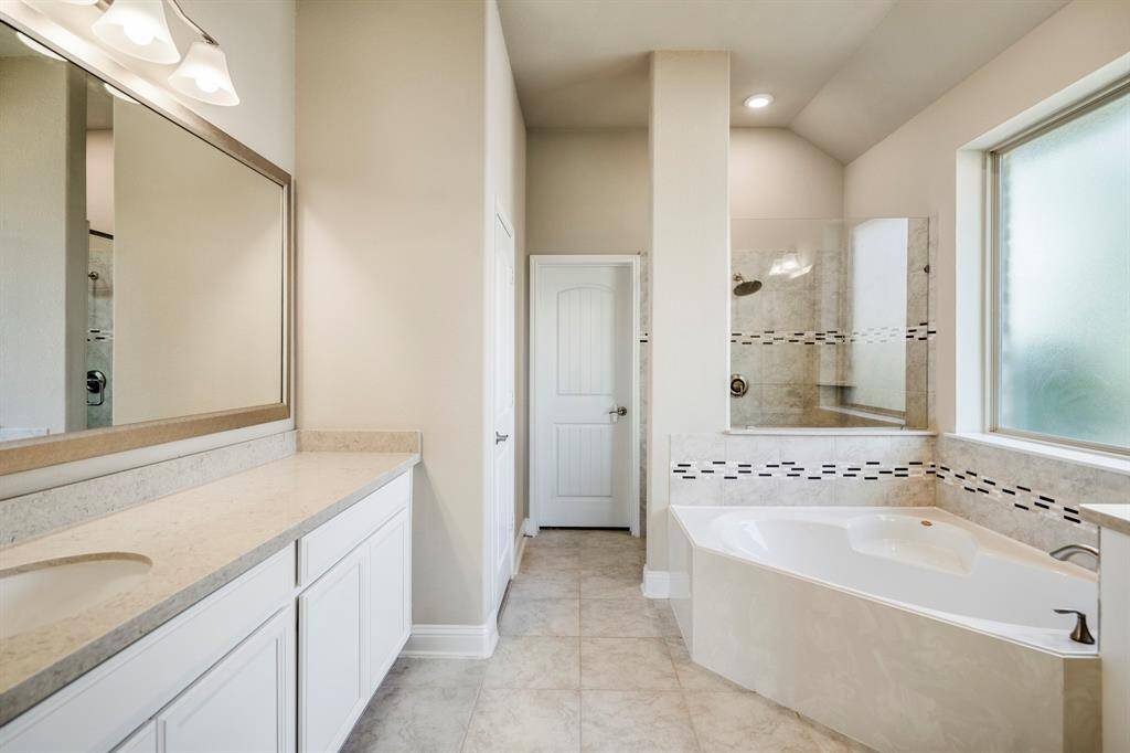 Notice wall-to-wall mirrors, soaking tub, and separate stand-up shower.