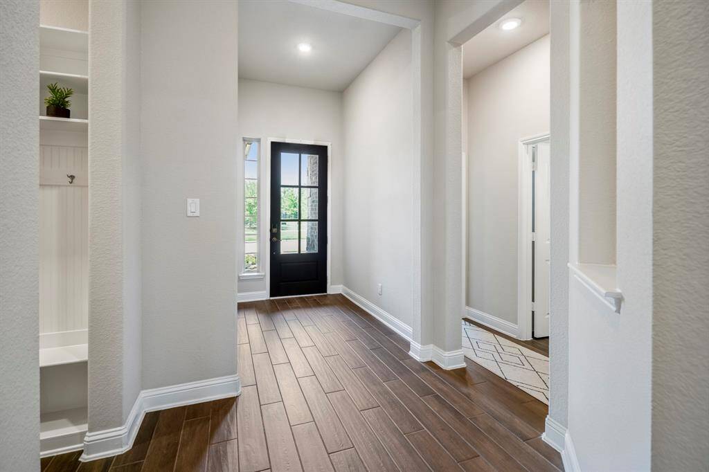 A look at the foyer that is spacious enough for entry table and art. Hallway on the right leads to two bedrooms and a full bathroom. Hallway on the left of this picture leads to another bedroom, mudroom, and entry into the garage.