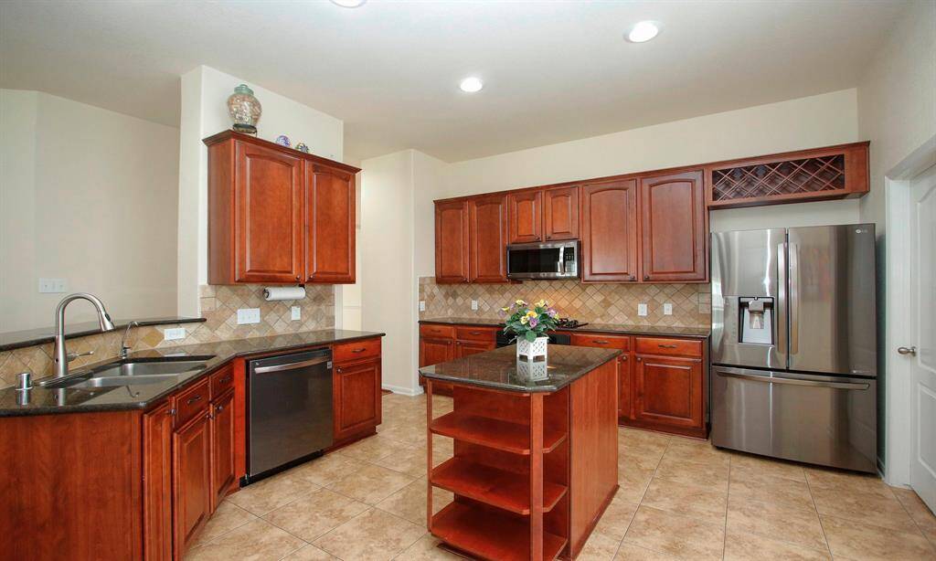 Newer stainless refrigerator will convey with the property. Display shelf above all the cabinets