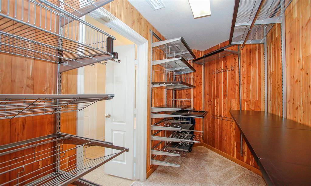 Super walk in primary closet built out with Elfa roll out built ins including a jewerly compartment
