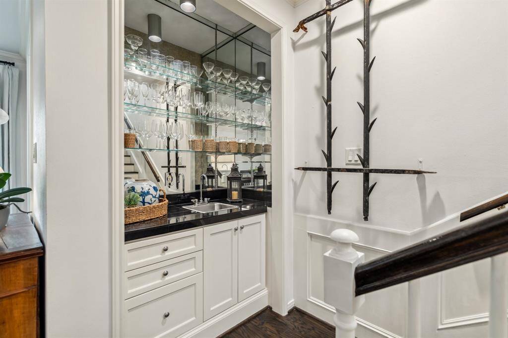A standout entertaining feature: the wet bar with a sink, ample built-in storage, and a mirrored backsplash with shelving.