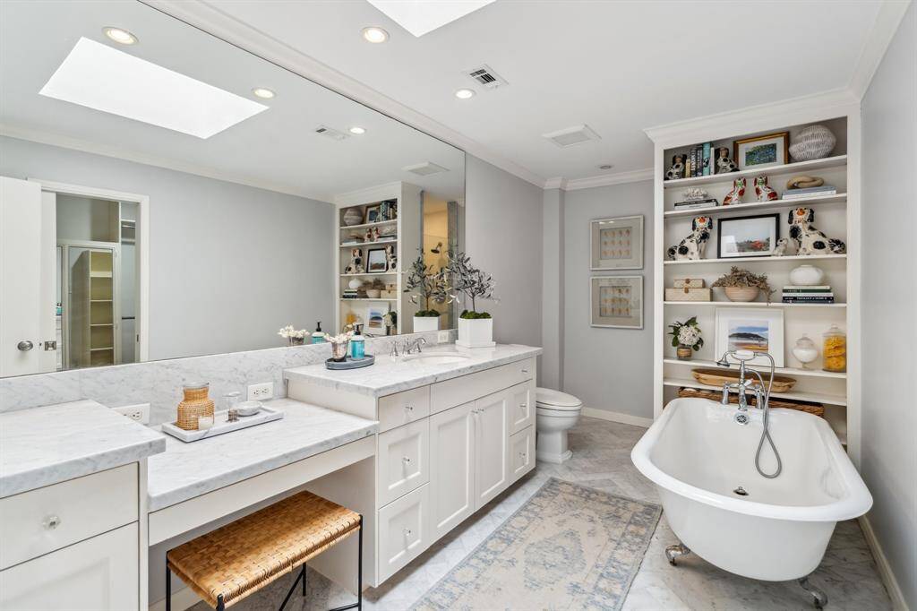 Fully renovated bathroom with custom cabinetry, updated countertops, and a skylight that fills the space with natural light.