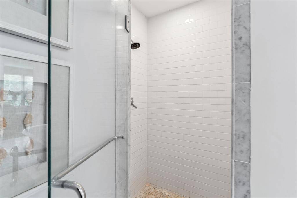 Modern walk-in shower framed with a glass door enclosure.