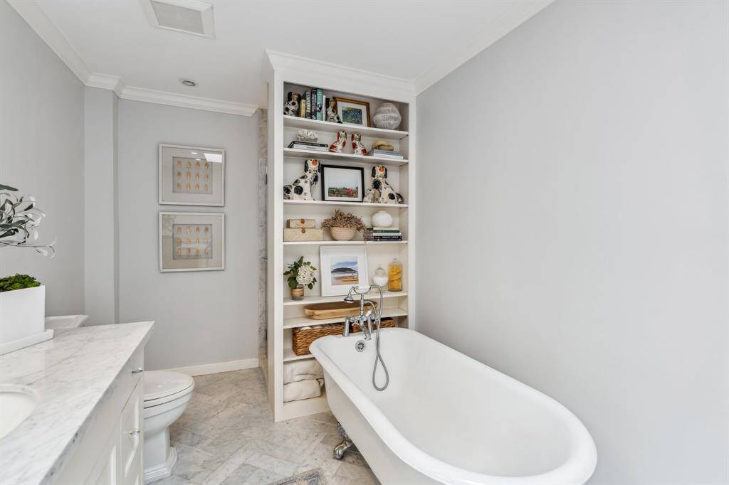 A classic clawfoot soaking tub offers the perfect spot to unwind—complete with a bookshelf for styling or storing your favorite reads.