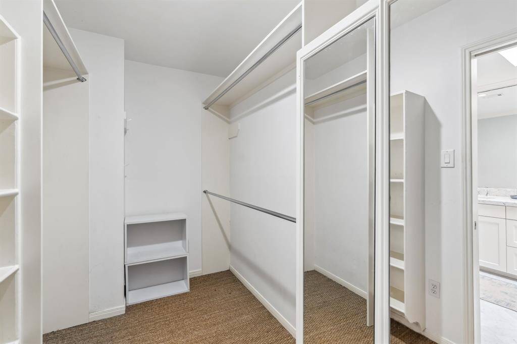 The second closet is a large walk-in off the bathroom, featuring ample built-in cabinetry.