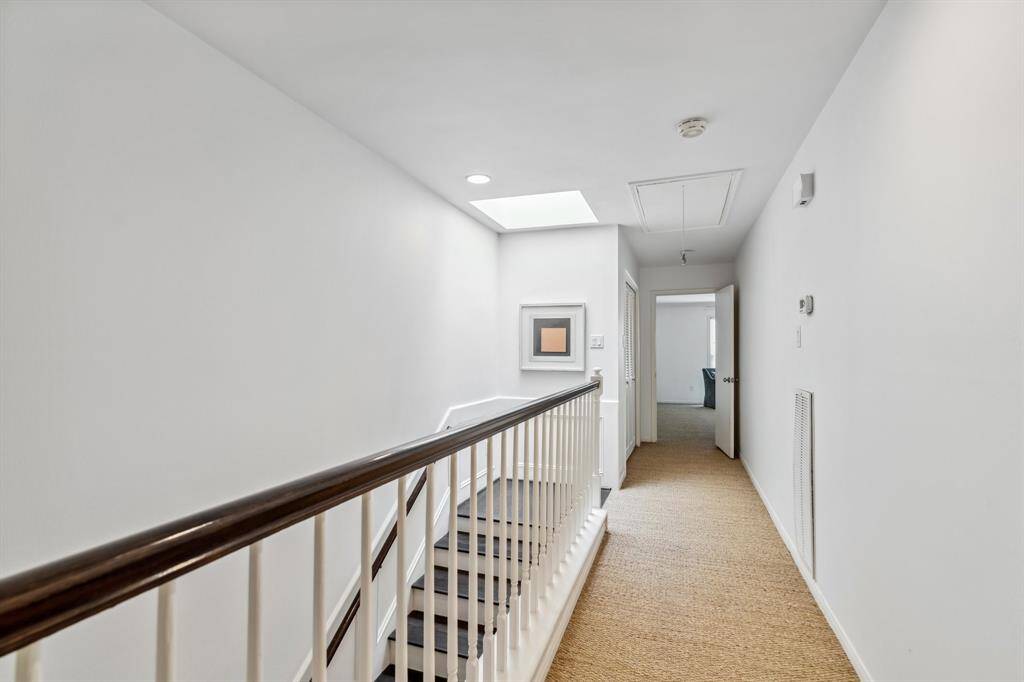 Upstairs hallway illuminated by a skylight, with an oversized closet on the left—ideal for storage. Bedrooms on either side provide plenty of privacy.