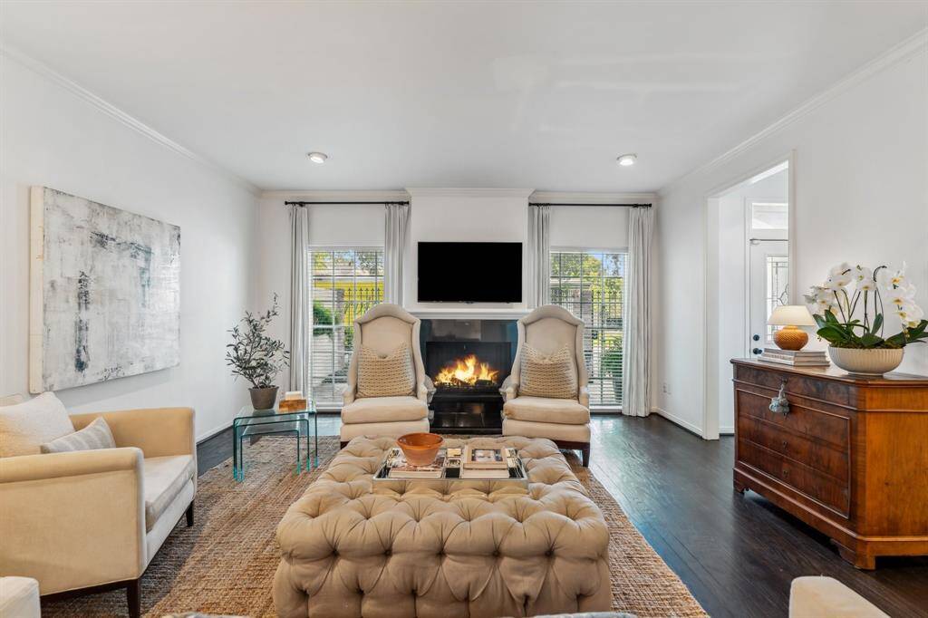 Between two expansive windows, a gas log fireplace with a tile-stone surround serves as the room’s focal point.