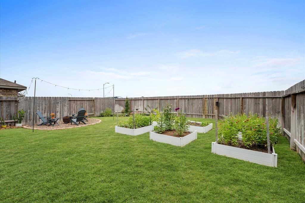 Backyard features a conversational fire pit, cut flower and vegetable gardens.
