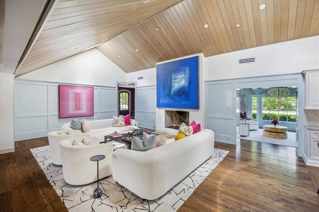 The formal living room features vaulted, wood-paneled ceilings with a cozy fireplace. The formal living room conveniently opens to the kitchen and breakfast nook.
