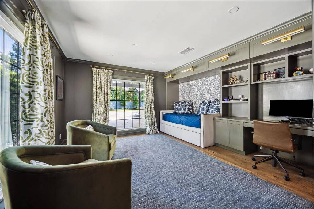The secondary bedroom features floor to ceiling windows with views of the backyard, an en-suite bathroom, and spacious closet.