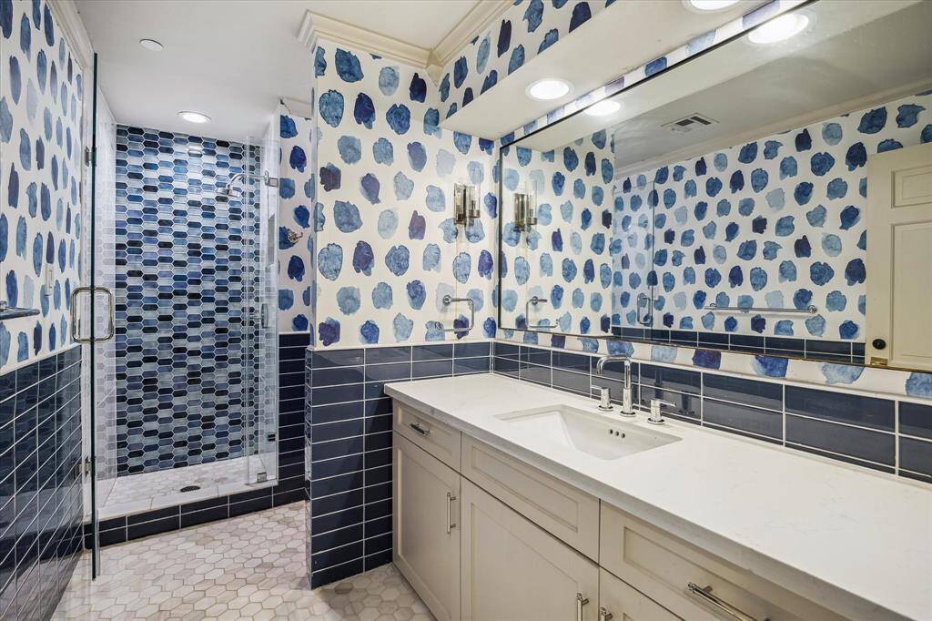 This secondary bathroom features a walk-in closet and large vanity.