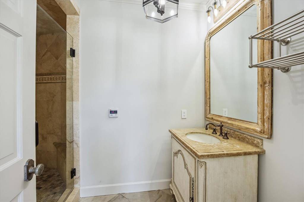 The bathroom in the guest house features a walk-in shower and tile flooring.