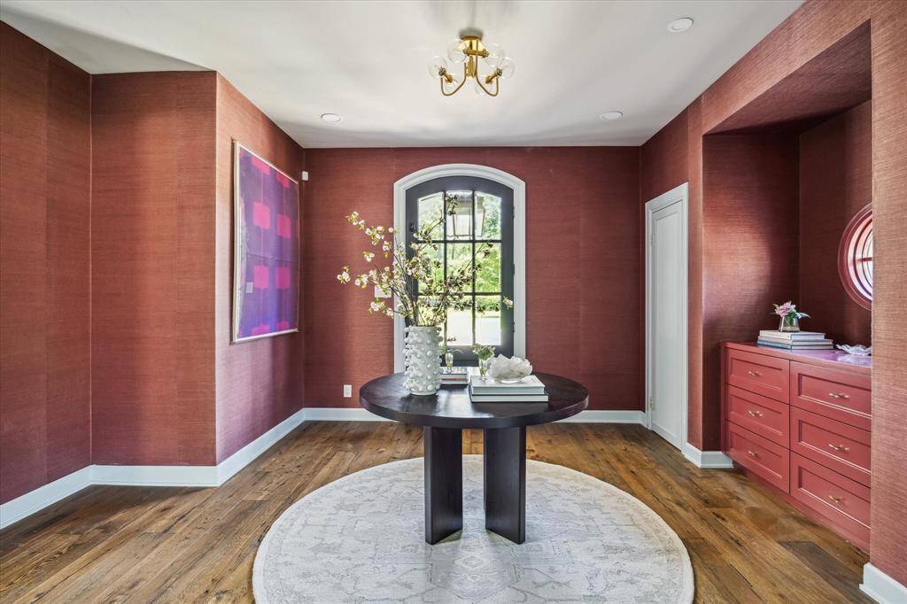 Upon entry you are greeted by an inviting foyer with grass cloth wallpaper, wood flooring, and dual coat closets.