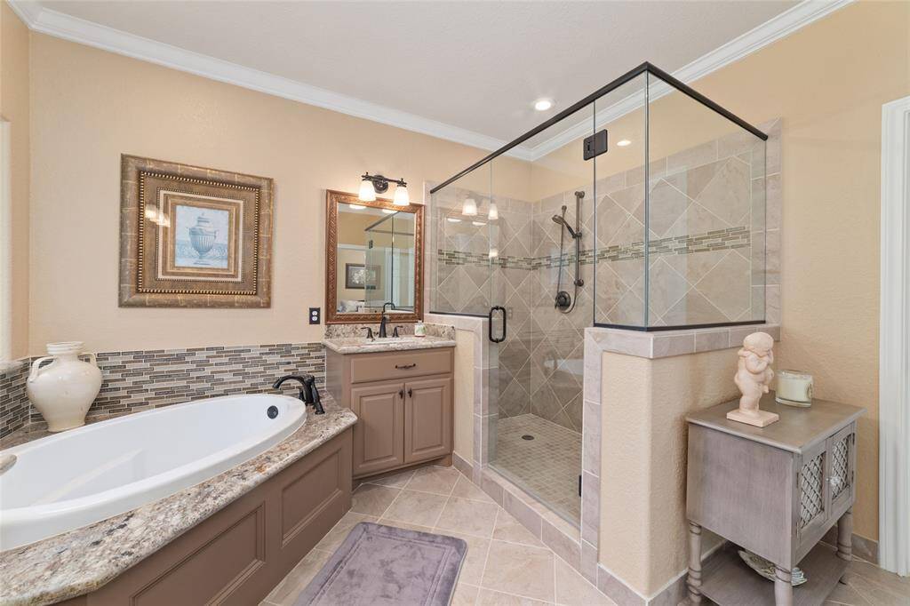A deep soaker tub invites relaxation, while the frameless glass shower offers a spa-like experience.