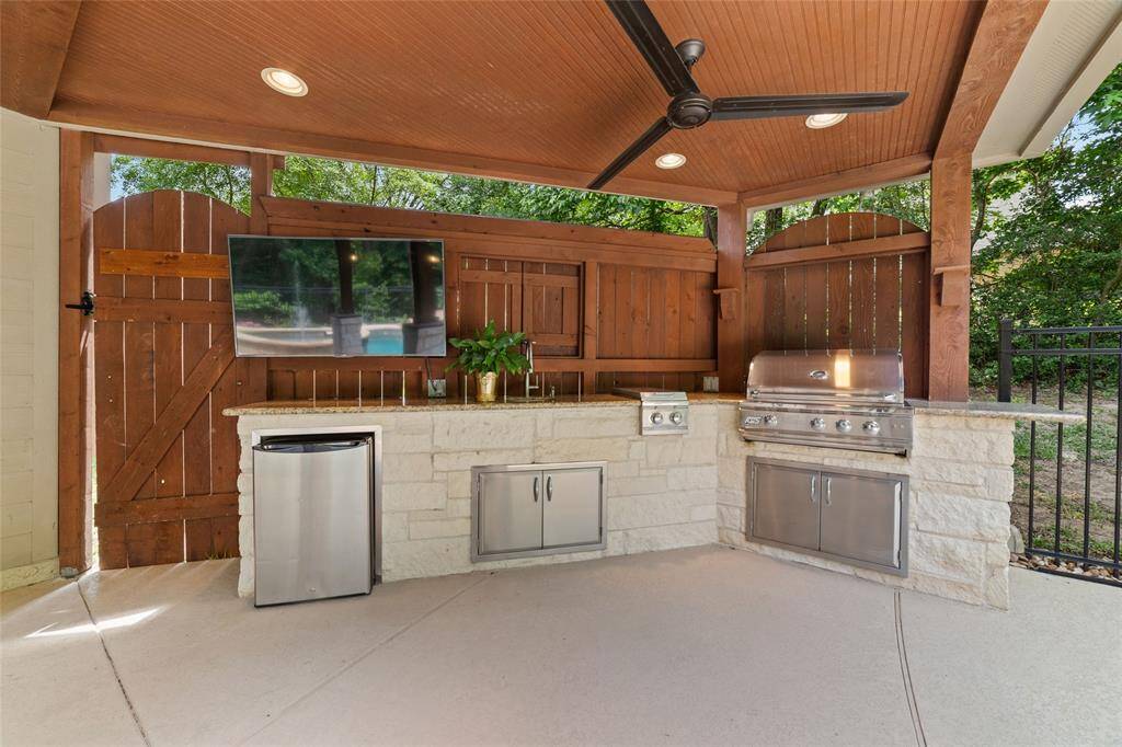 The outdoor kitchen includes built-in appliances and prep space, ideal for entertaining.