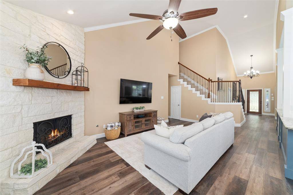 A dramatic limestone fireplace rises floor to ceiling, creating a stunning focal point in the living area.