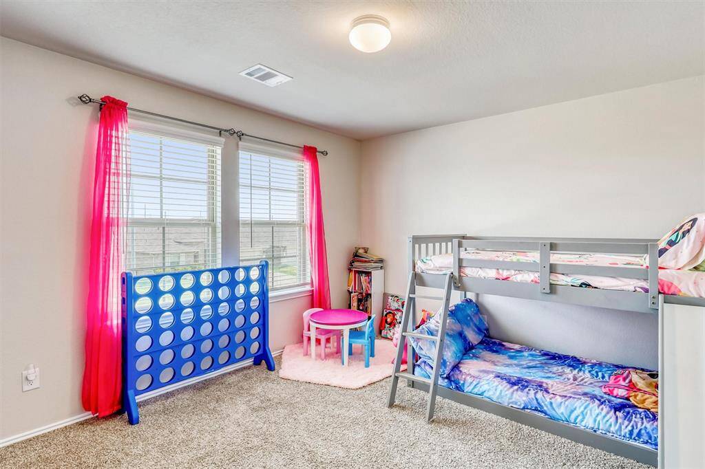 Another spacious bedroom, carpeted and bright, offering the ideal canvas for a child’s imagination or a personalized retreat.