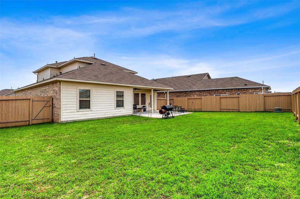 The view from the rear lawn highlights the generous patio—an ideal transition between indoor comfort and outdoor enjoyment.