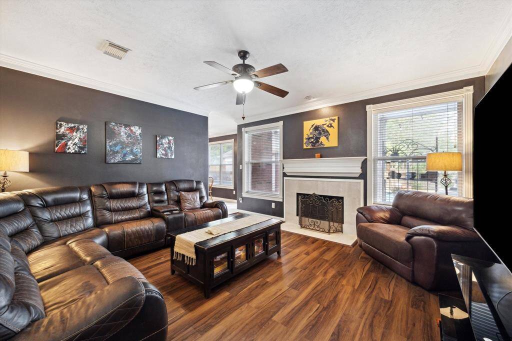 THE DEN ALSO FEATURES A FIREPLACE AND CROWN MOLDING.