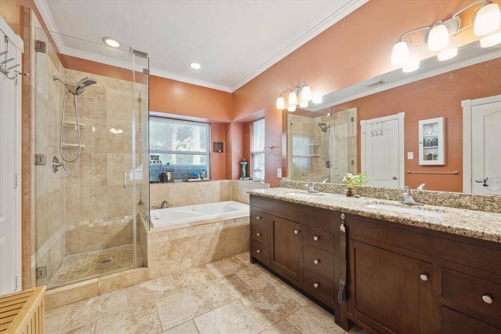 THE UPDATED BATH FEATURES A WHIRLPOOL TUB, DOUBLE SINKS WITH GRANITE COUNTERS AND A WALK-IN SHOWER WITH CUSTOM TILE SURROUND WITH FRAMELESS GLASS ENCLOSURE.