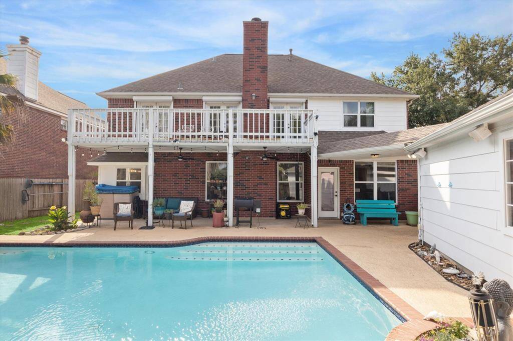 VIEW OF THE COVERED PATIO AND BALCONY FROM THE POOL.