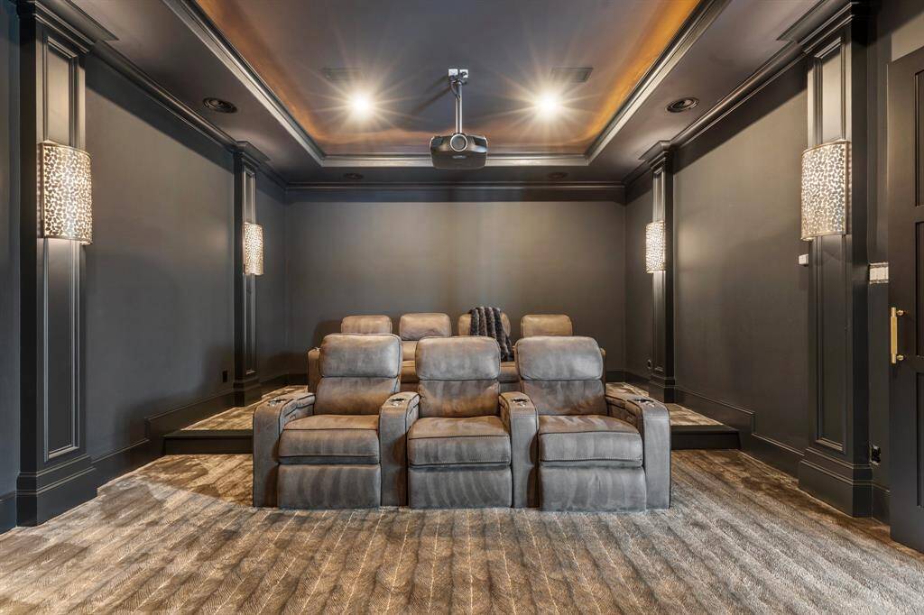 The downstairs theatre room is designed for entertainment, providing ample seating space and equipped with a theatre projector, screen, and all necessary equipment for movie nights.