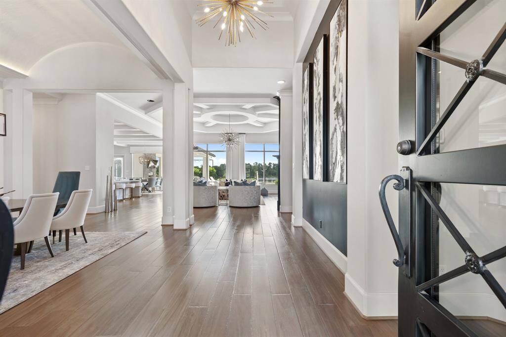 Upon entering through the grand double doors crafted from iron and glass, guests are greeted by a stunning foyer that sets the tone for the luxury found throughout the residence.