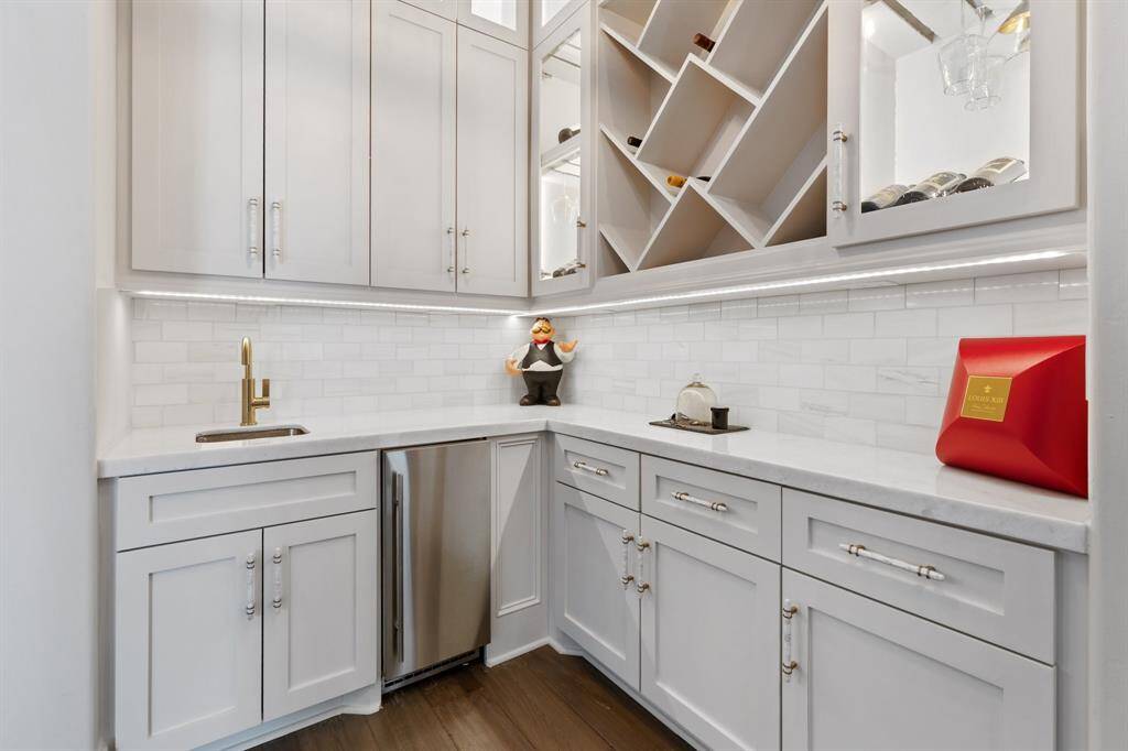 Adjacent to the dining room, a well-appointed web bar features ample storage and is designed for both functionality and style, making it the ideal spot for entertaining guests.