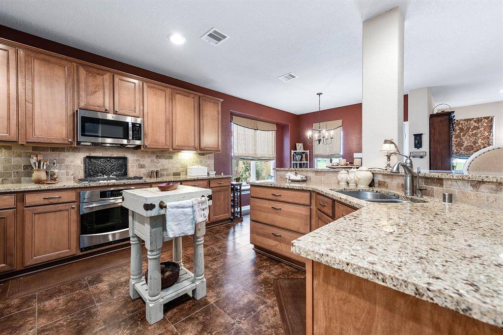 Stainless steel appliances, granite countertops and tile floor compliment the room