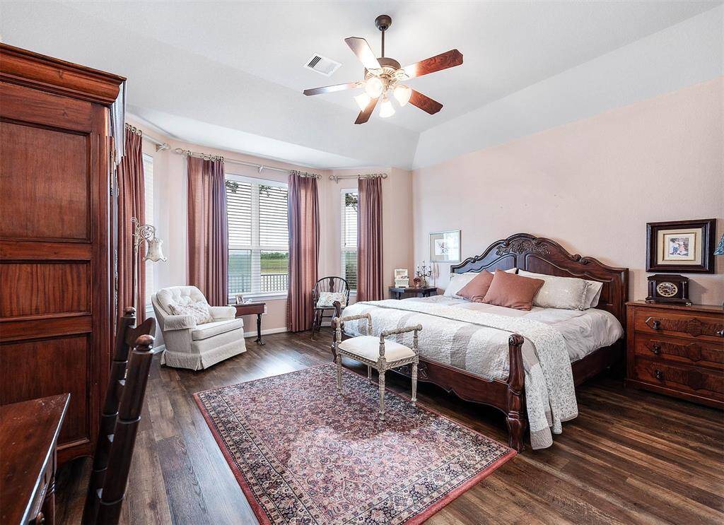 The rich wood floors extend into the first of two Primary bedrooms:  this being the room located on the ground floor and just off the Family room.
