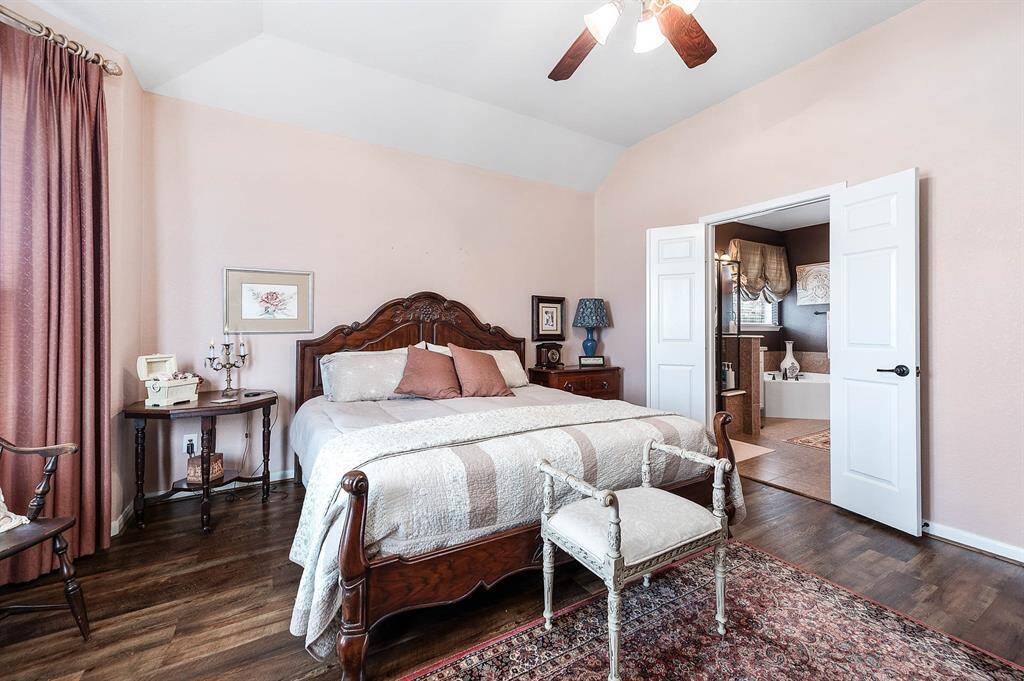 Light neutral colors, ceiling fan with light fixture, and lots of wall space -- all leading through double doors to the ensuite bath.