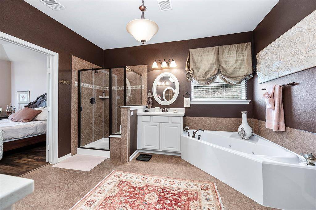 Corner tub, oversized shower and separate vanities complete this room