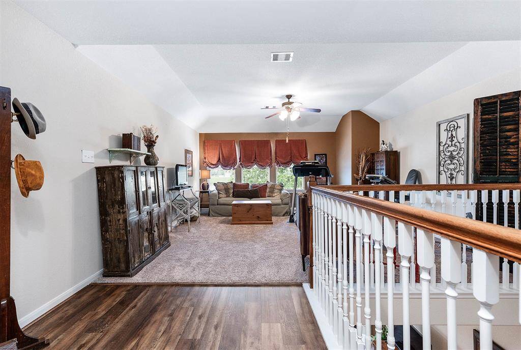 Upstairs Gameroom features coffered ceilings, a wall of windows and space for enjoyment.
