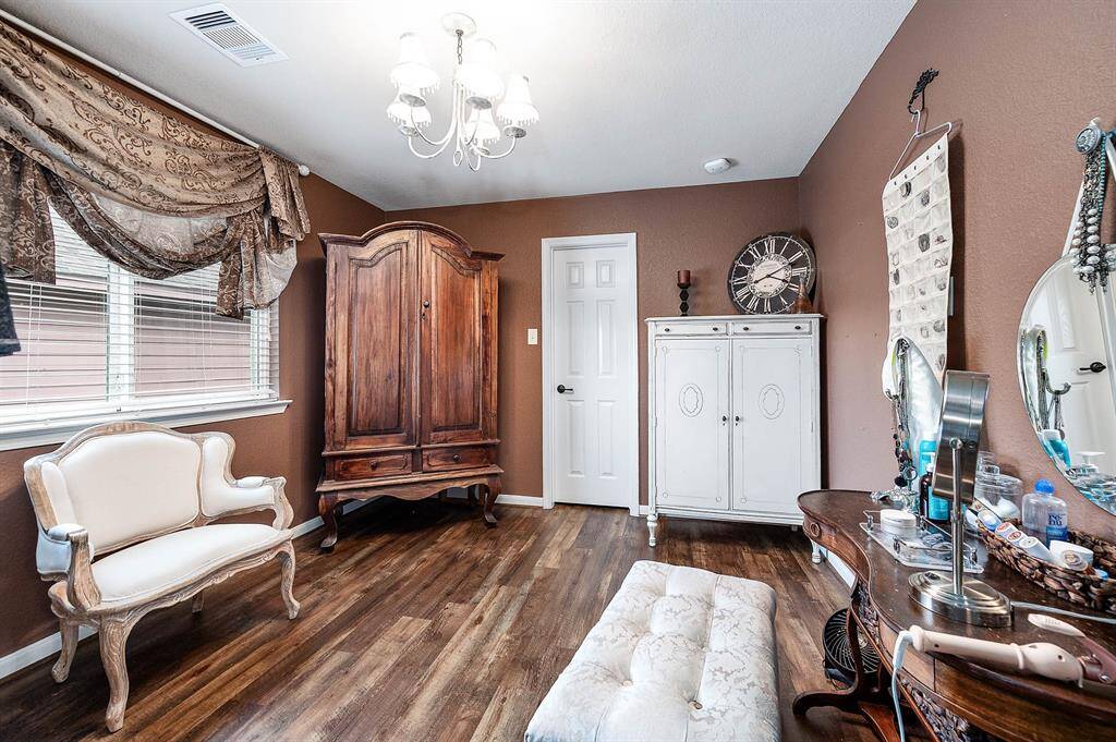 This shot shows the dressing area/ sitting room of this upstairs "primary bedroom", accessed from bedroom through double French doors --  with ample floor and wall space for all your needs. Closets and storage abound in this home!