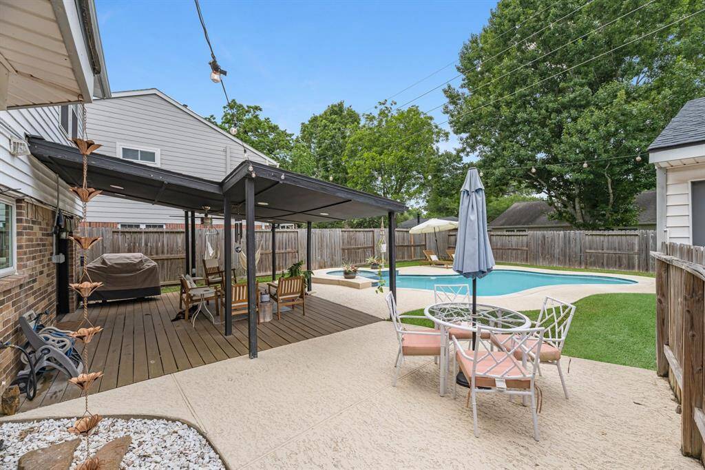 The covered patio overlooks the heater inground pool.
