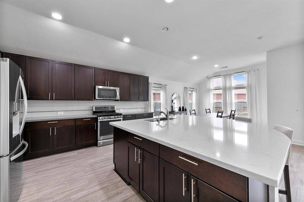 This chef worthy kitchen offers a freestanding oven and a gas cooktop under a mounted microwave.