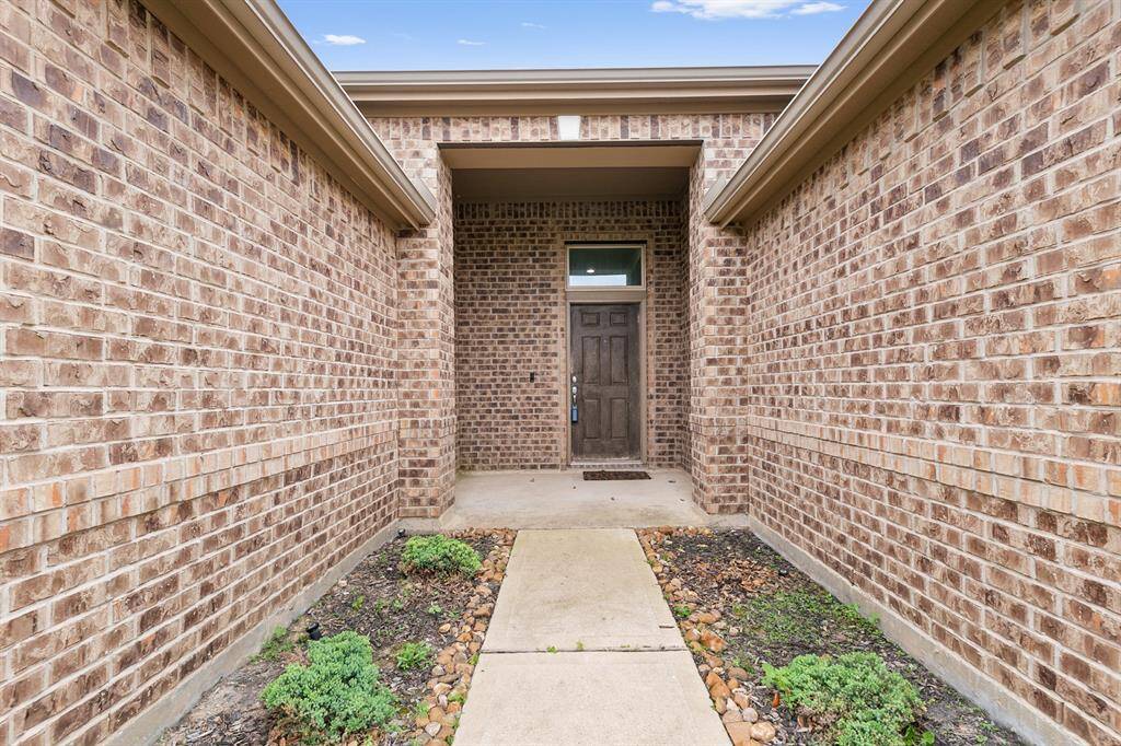 A landscaped front walk leads to a covered porch entry.