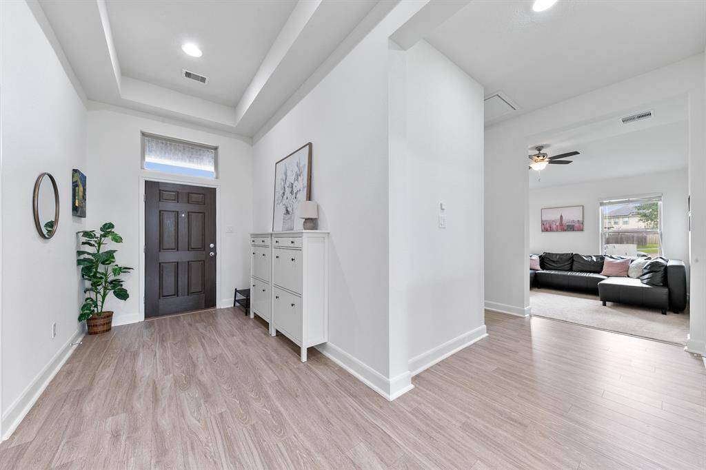 Around and to the left of the entry, you'll find a carpeted formal living room tucked away from the rest of the home, creating a cozy spot for quiet conversations.