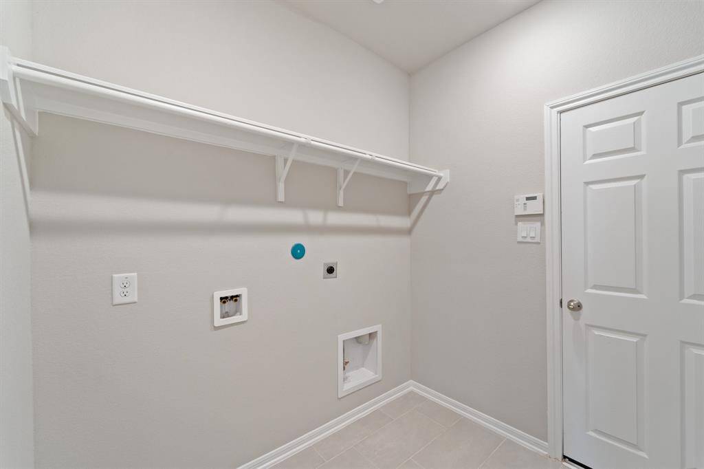The laundry room layout is carefully planned for optimal workflow with designated areas for washing, drying, and storing.