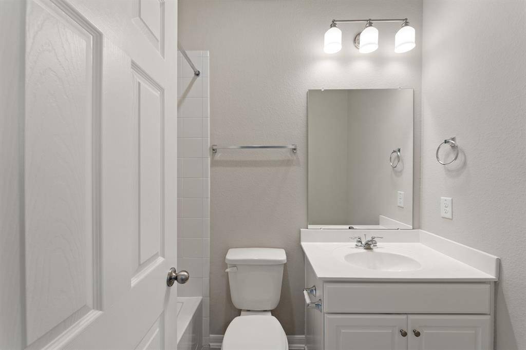 The secondary bath features tile flooring, white cabinetry and light countertops and a shower/tub combo. Perfect for accommodating any visiting family and friends.
