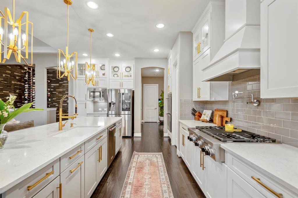 You will love the details of this kitchen! Featuring brushed gold cabinet hardware, pot filler, modern tile backsplash, gas range, and tons of storage!