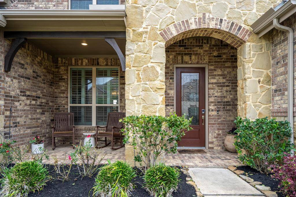As you approach the front door, you are greeted by a stunning brick and stone elevation and a spacious front porch—perfect for welcoming guests! The 8-foot door entry, complete with keyless access, smart door bell, and elegant recessed lighting, sets the tone for the luxury within.