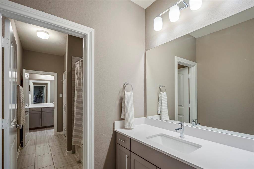 A jack and jill bathroom is the perfect set up for sharing! This private vanity area features an oversized vanity with quartz countertops, a large mirror, and plenty of storage.