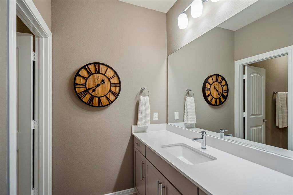 A jack and jill bathroom is the perfect set up for sharing! This private vanity area features an oversized vanity with quartz countertops, a large mirror, and plenty of storage.