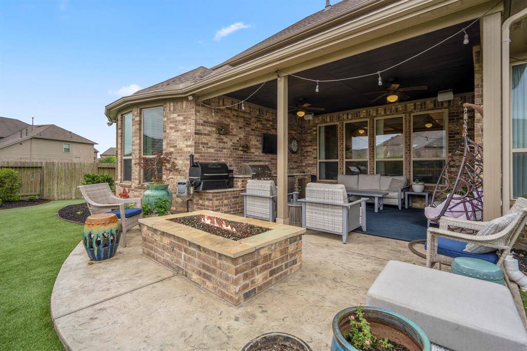 Outdoor living at its finest! This covered patio with extended flatwork, a cozy fire pit, and outdoor kitchen, is perfect for relaxing or entertaining year-round. Just add good company and enjoy!